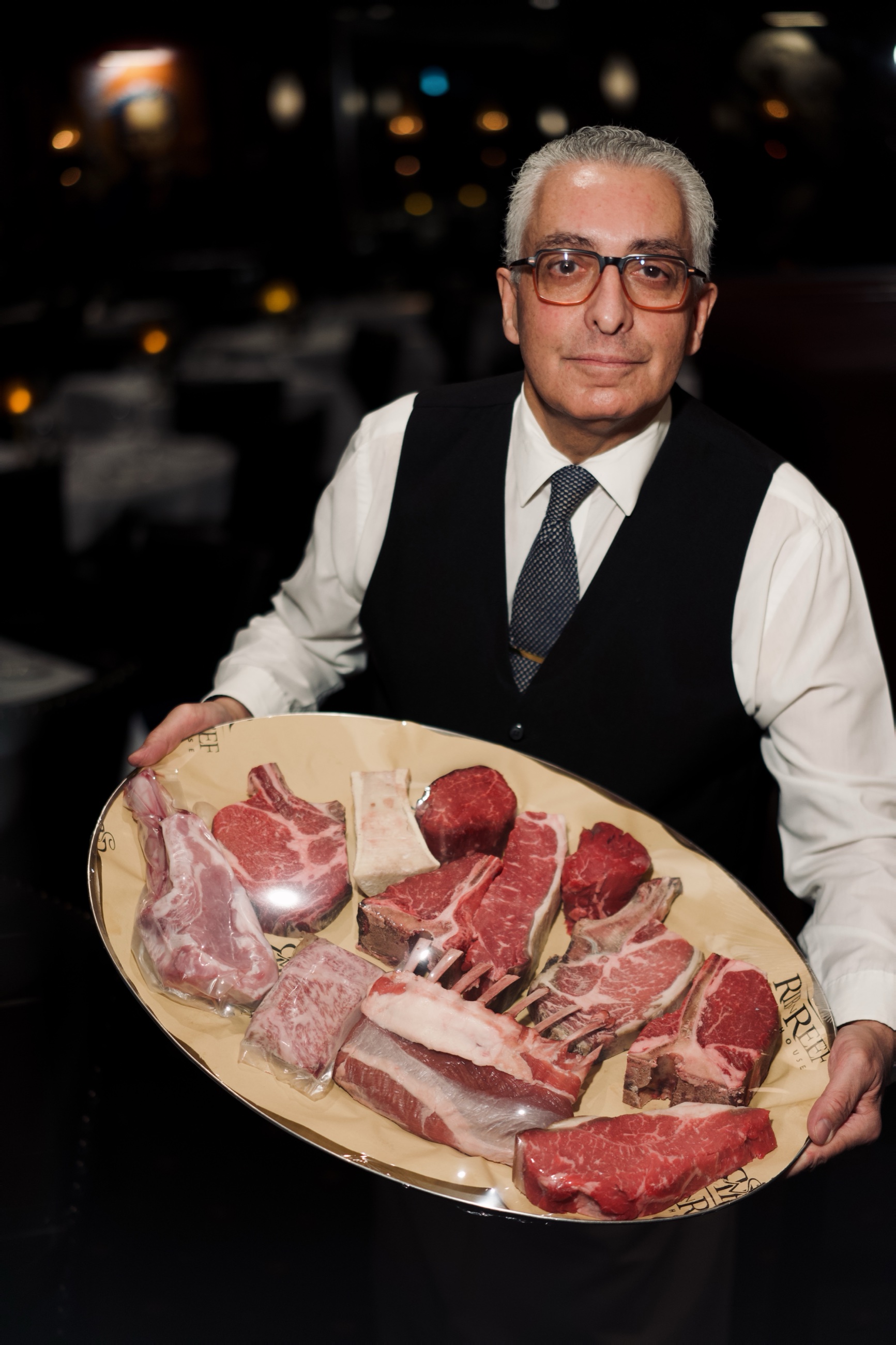 A server presenting the raw selection of USDA Prime cuts
